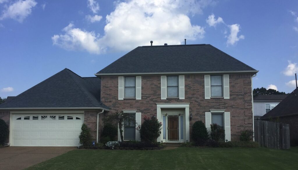 Two-story brick house with garage and lawn.