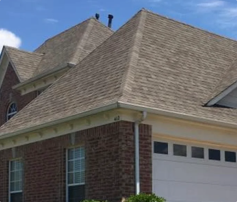 Brick house with sloped roof and garage door.