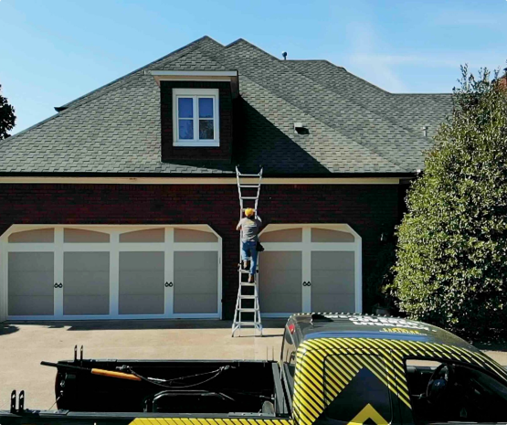 Worker climbs ladder to inspect house roof.