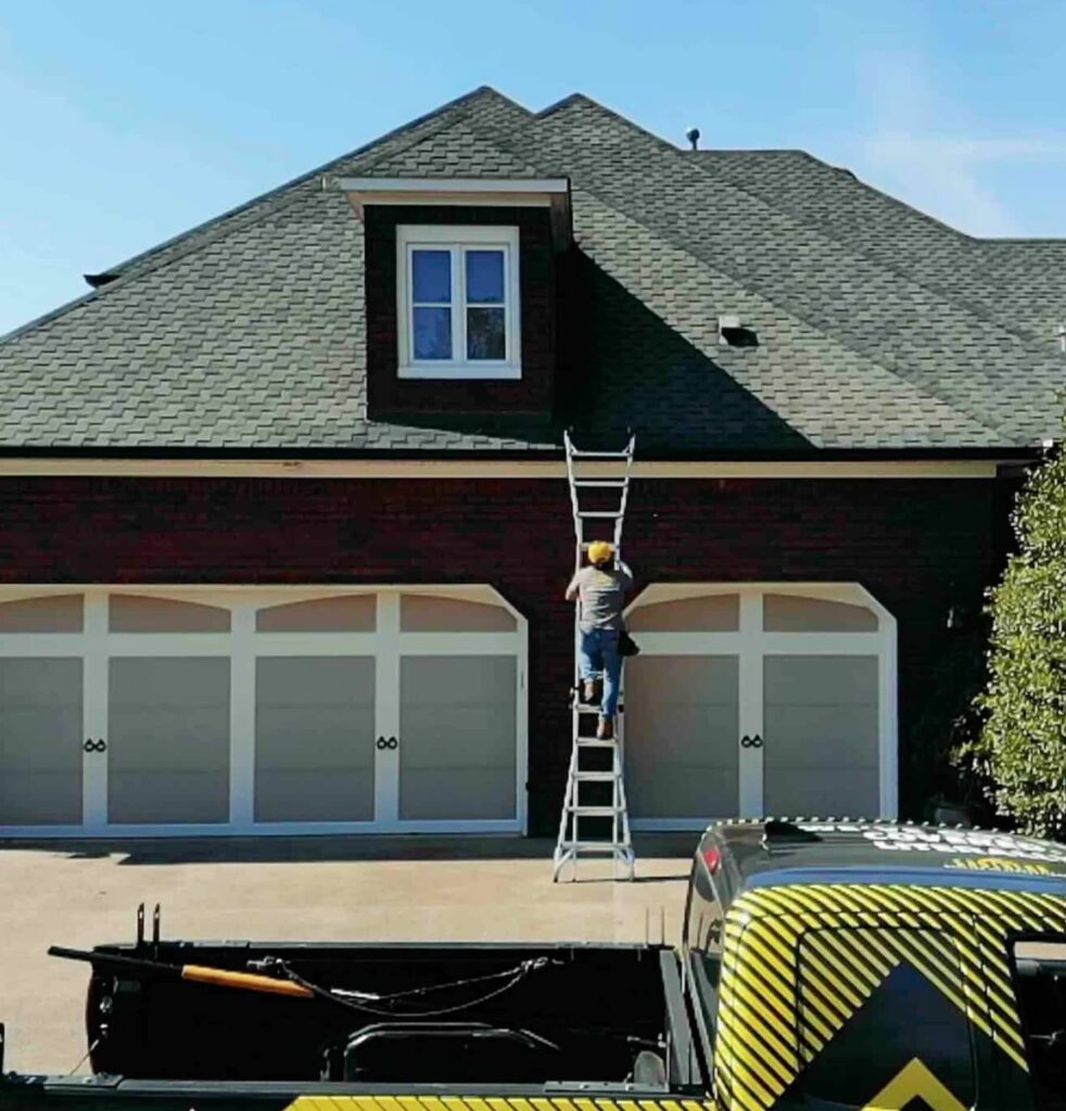 Person climbing ladder to house roof
