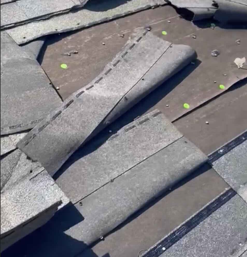 Damaged roof shingles needing urgent repair